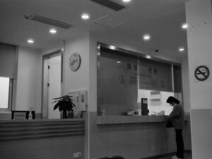 a black and white photo of a woman standing in front of a counter