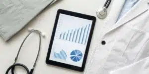 A tablet with billing charts and a stethoscope for a guide on what physician bill pay is.