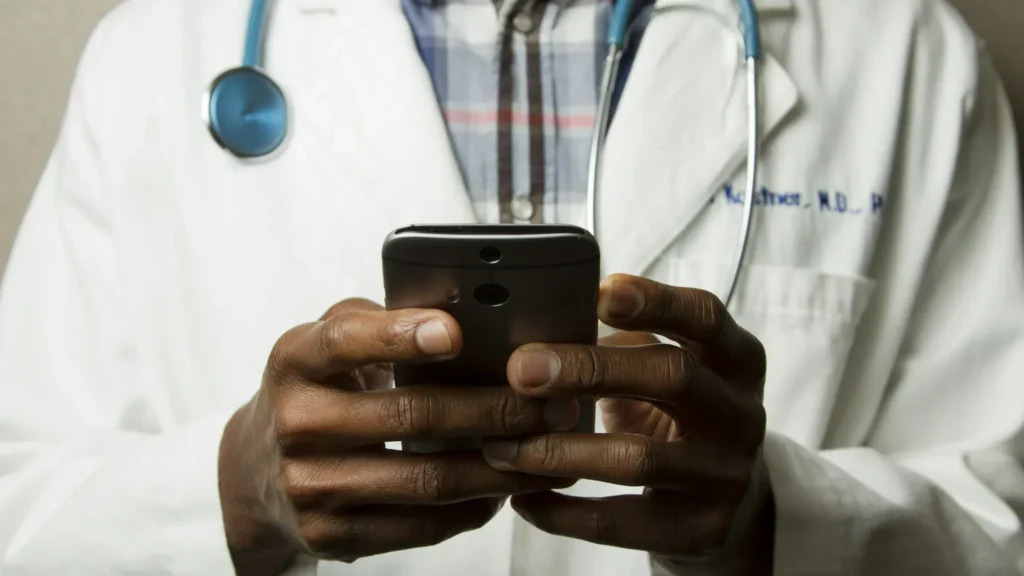 Internal medicine physician reviewing billing documents and patient charts at a modern medical office desk